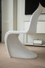 Modern white plastic chair in a minimalistic room with light wood flooring.