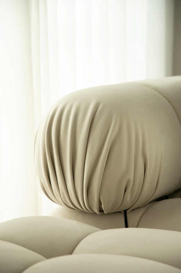 Beige sofa with a cushion in a softly lit room