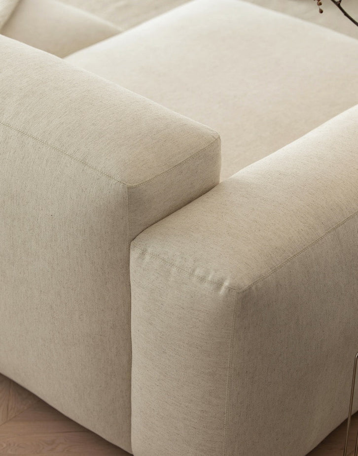 Beige sofa with a focus on texture and stitching detail.