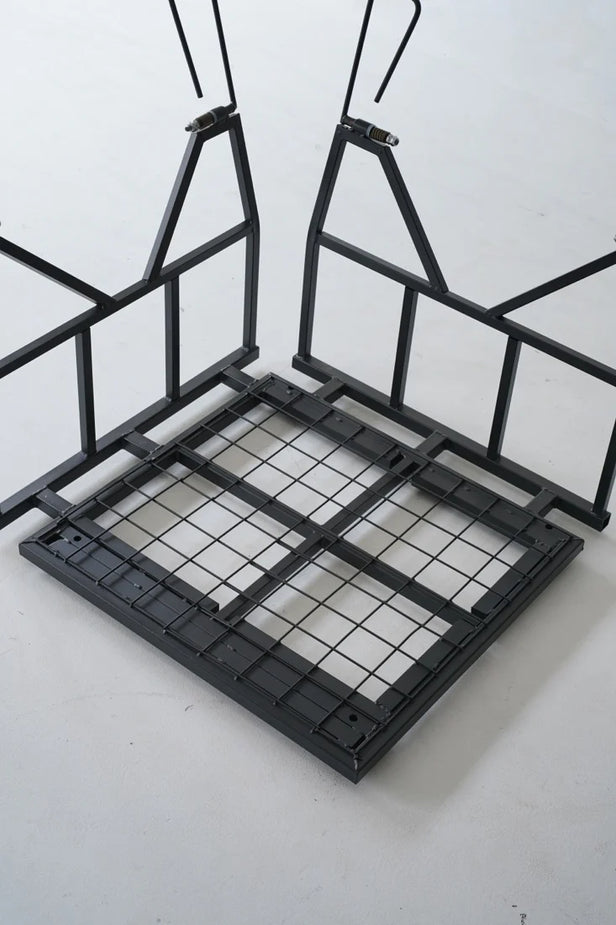 Black metal bed frame with grid design on a white background