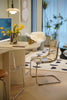 Modern living room with a round table, dining room chairs, and decorative elements.
