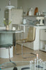 Modern kitchen with white cabinets, a glass table, and transparent dining room  chairs.