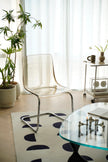 Modern living room with transparent living room chair, glass table, and decorative elements.