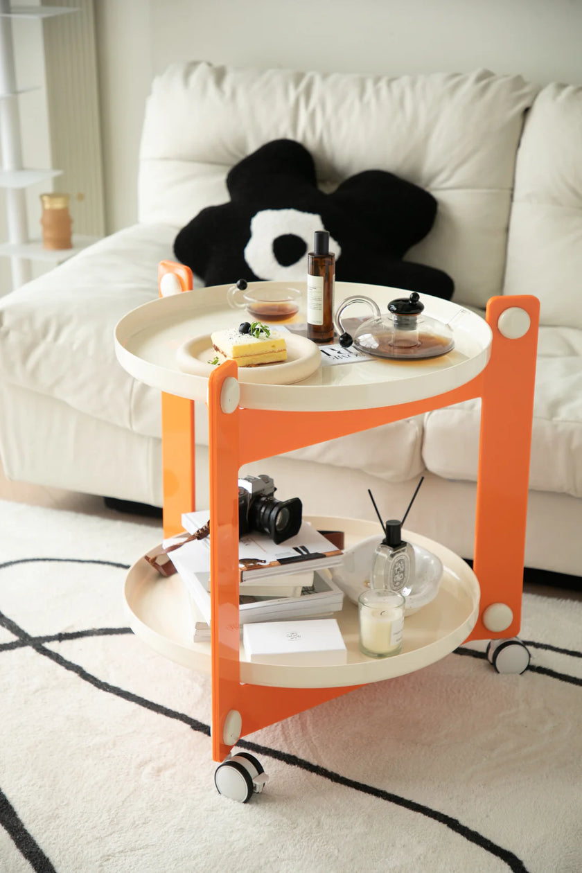 Orange and white sofa side table with drinks and snacks on a living room floor.