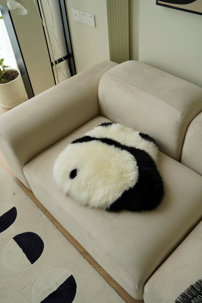 Panda-shaped pillow on a beige sofa in a living room setting
