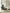 Lady sitting on a modern black recliner chair reading a book in a minimalistic living room.