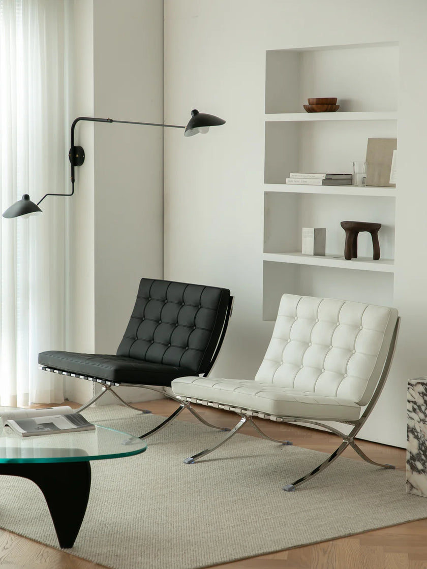 Modern living room with two barcelona chairs and a glass coffee table.
