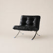 Black leather chair with metal legs on a beige background