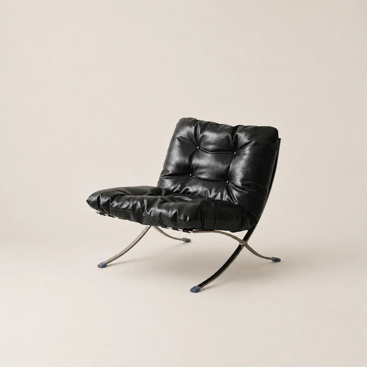 Black leather chair with metal legs on a beige background
