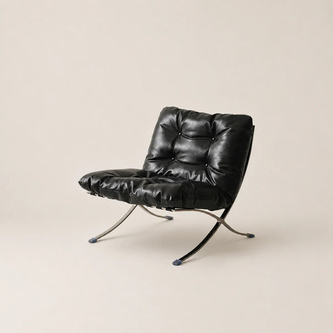 Black leather chair with metal legs on a beige background