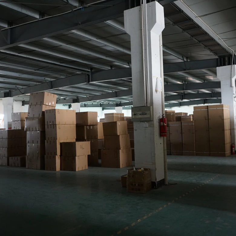Storage warehouse with stacked cardboard boxes and a person in the distance.