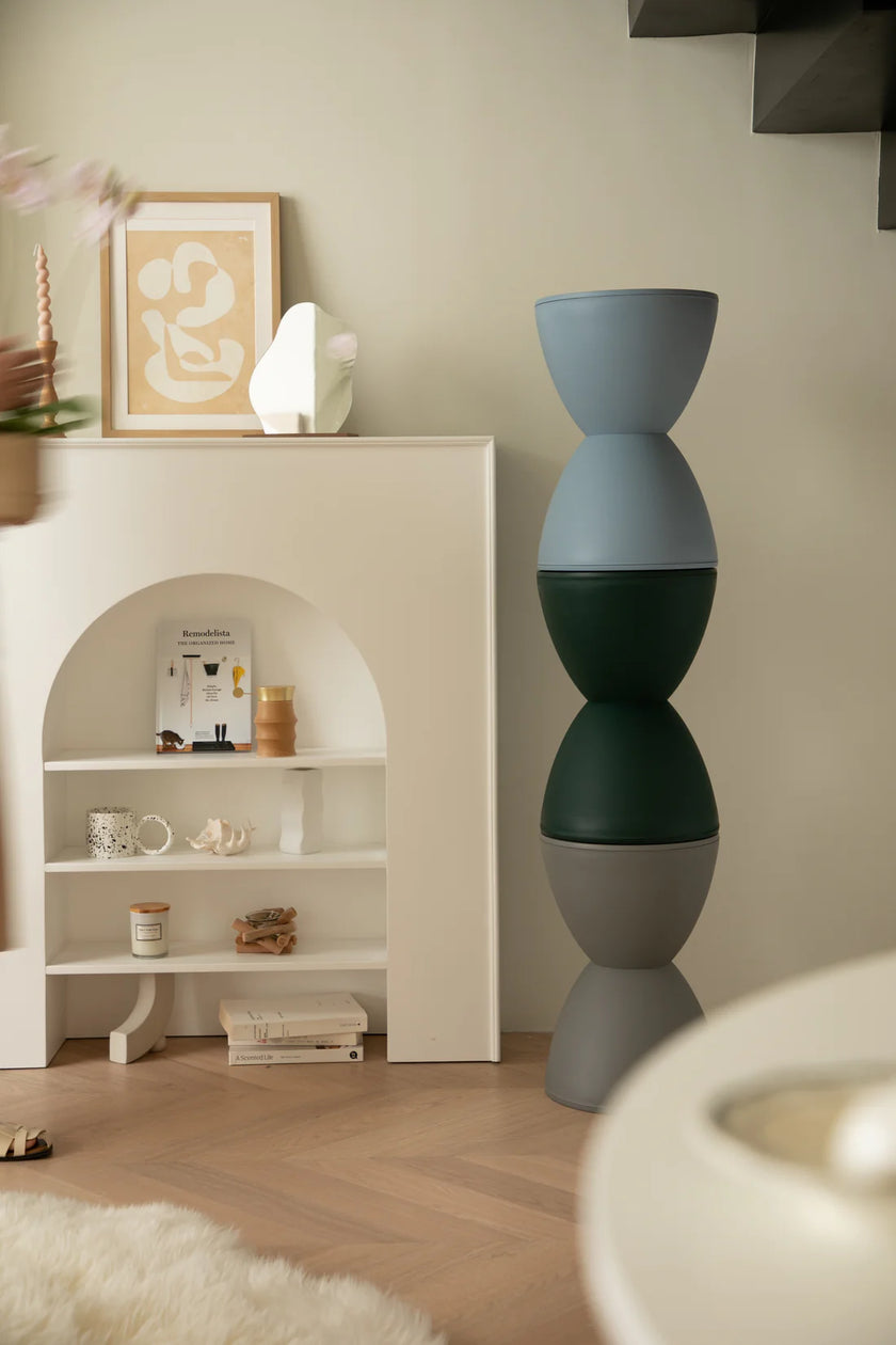 Decorative vase with a modern design in a room with shower stools and wall art.