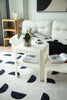 Living room with white sofa, outdoor coffee table, and patterned rug