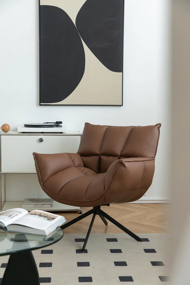 Brown leather swivel chair in a modern room with abstract art on the wall.