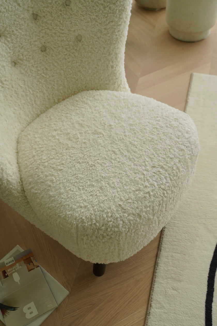 Close-up of a textured white sofa chair with a blurred background