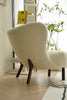 Beige sofa reclining chair in a modern interior setting with a plant and magazine in the background.