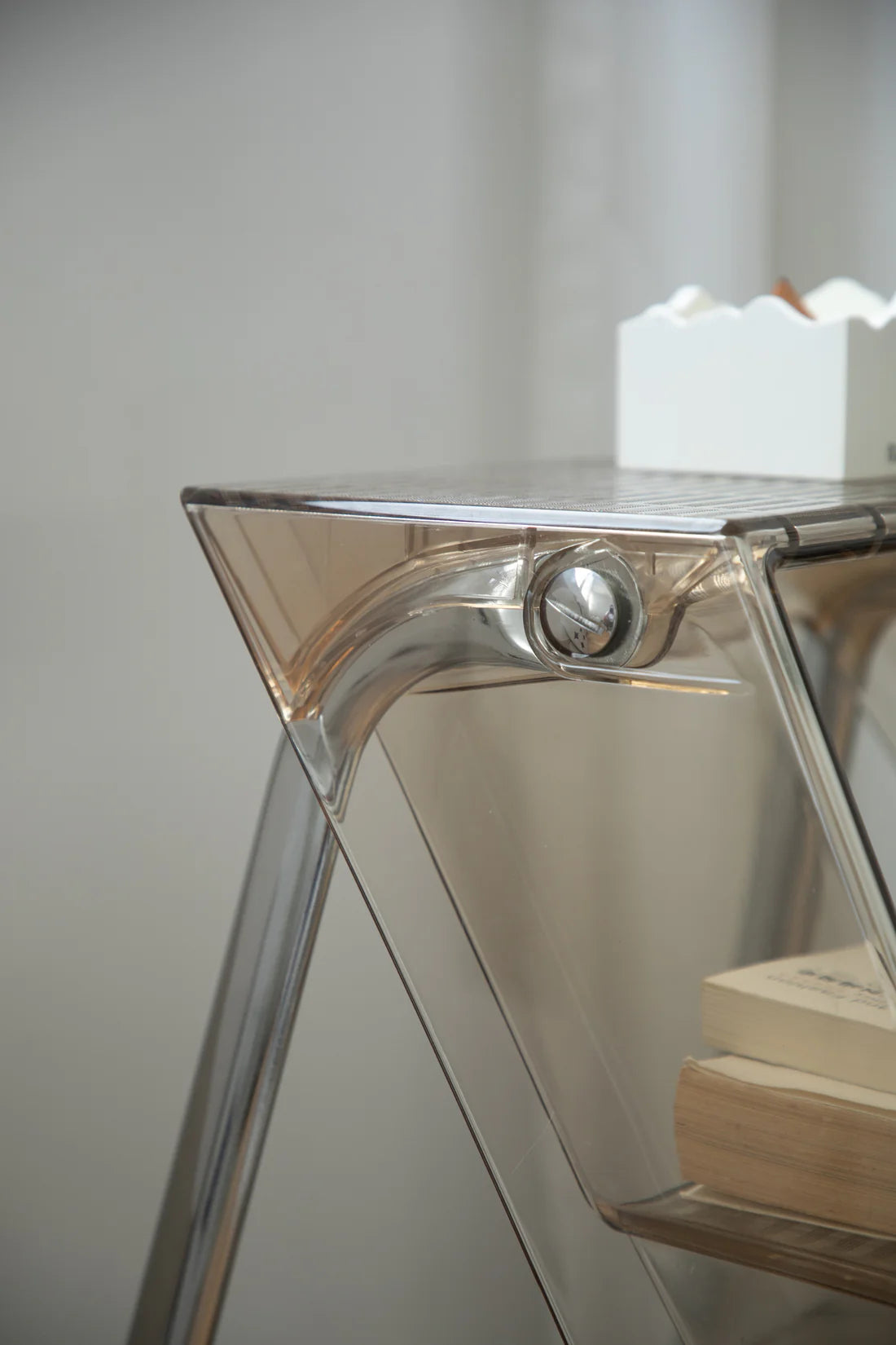 Metallic storage shelf with a reflective surface against a neutral background