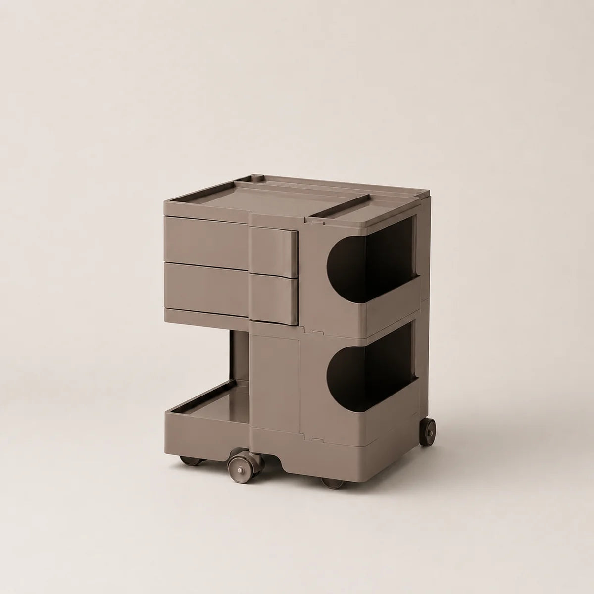 A modern, minimalist two-tier rolling storage cart in a warm brown color, featuring a top drawer unit, open shelves with curved cutouts, and a bottom tray on wheels, set against a solid light beige background.