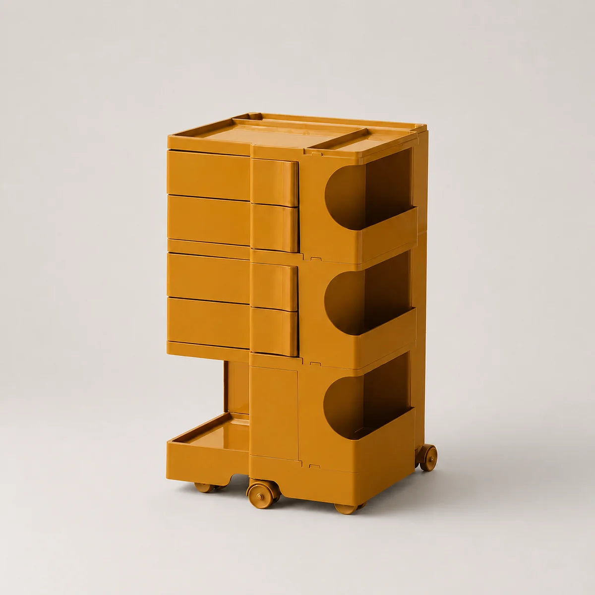 A mustard yellow storage cart with multiple drawers, open shelves, and small wheels, photographed on a clean light gray studio background.