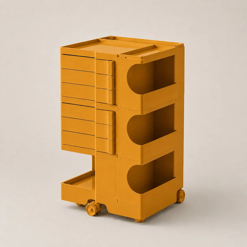 A mustard yellow rolling storage cart with multiple drawers and open shelves, photographed on a clean light gray studio background.