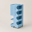 A light blue storage cart with multiple drawers, open shelves, and wheels, shown on a plain beige background.