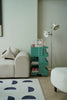 Modern living room with a white sofa, utility cart with wheels or teal side table, and decorative items.