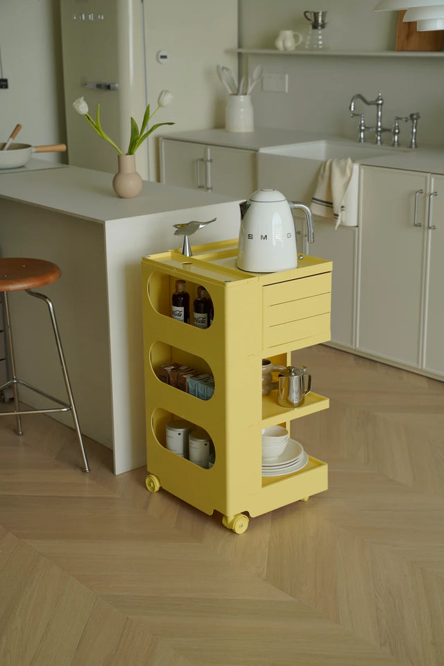 Yellow utility cart with wheels with various items in a modern kitchen setting