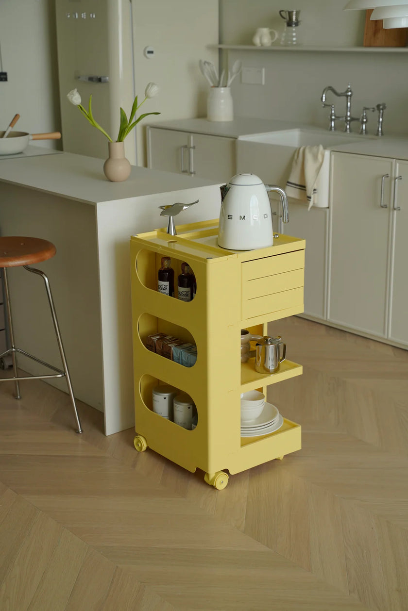 Yellow utility cart with wheels with various items in a modern kitchen setting