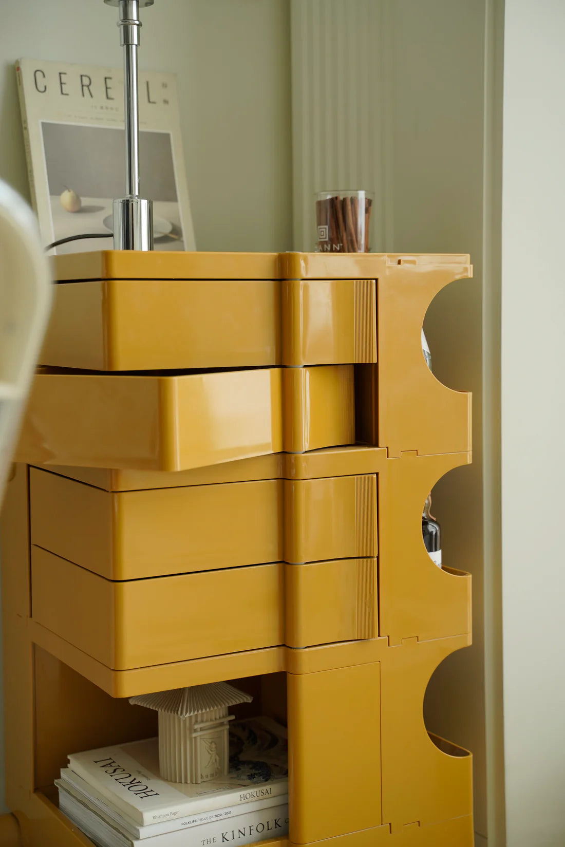 Yellow 4 tier storage unit with drawers in a room setting