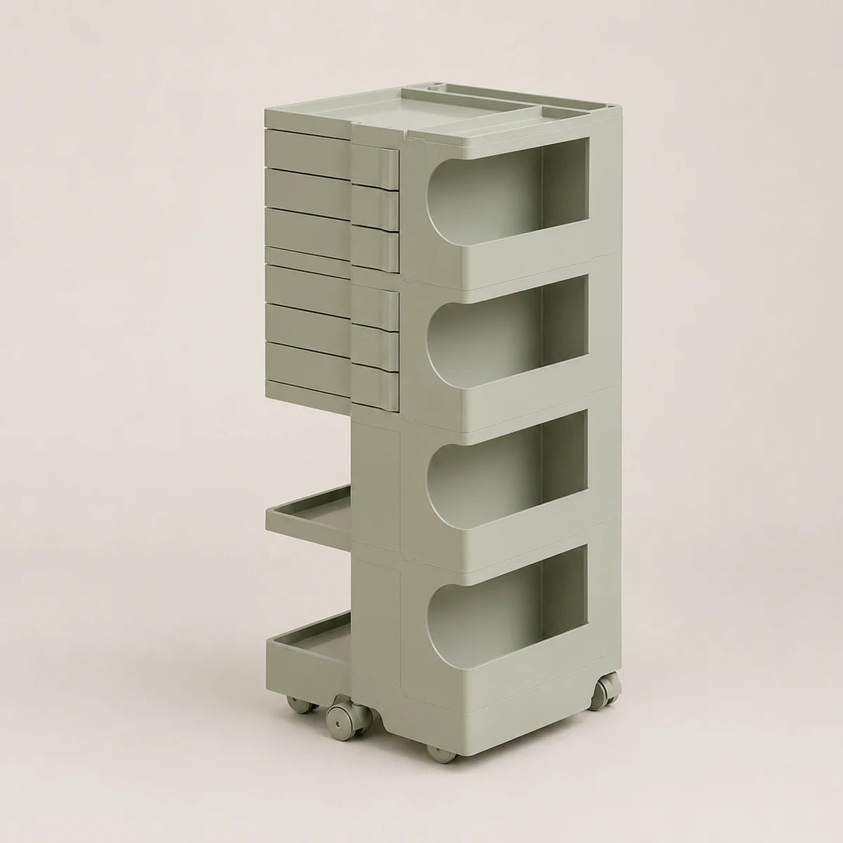 A light sage green rolling storage cart with multiple tiers, open shelves, and a stack of drawer fronts on the left side, set against a solid light beige background.