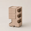 A muted pink plastic rolling storage organizer with four drawers on the left and three open shelves on the right, shown on a clean, light beige background.