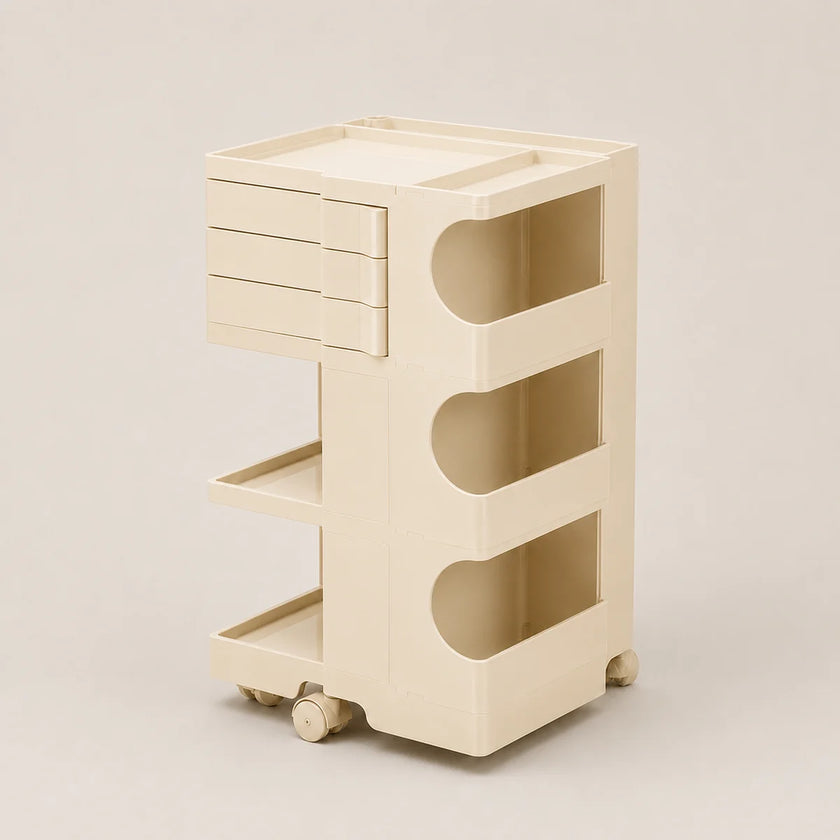 A cream-colored plastic rolling storage cart with three drawers, three open shelves, and wheels, shown on a neutral beige background.