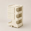 An off-white ABS rolling organizer cart with six drawers on the left and three open storage compartments on the right, set against a solid light beige background.