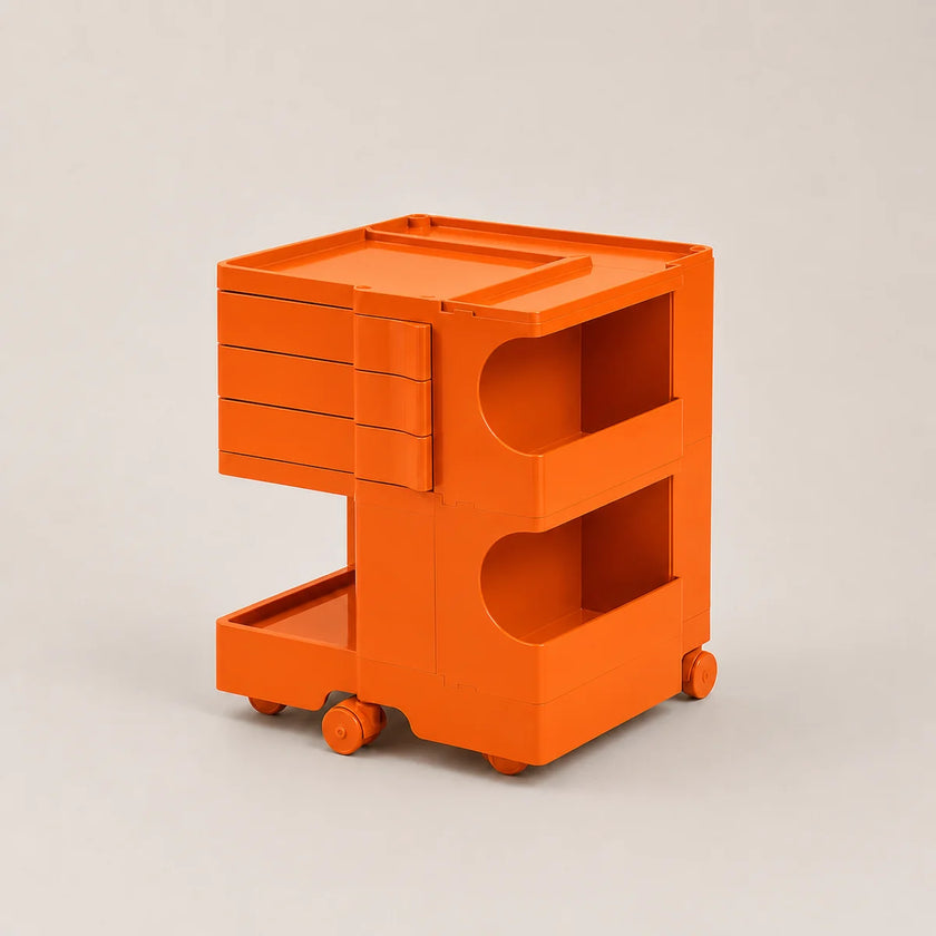 Bright orange ABS plastic storage cart with three drawers, two open shelves, and small caster wheels, photographed on a clean light gray studio background.