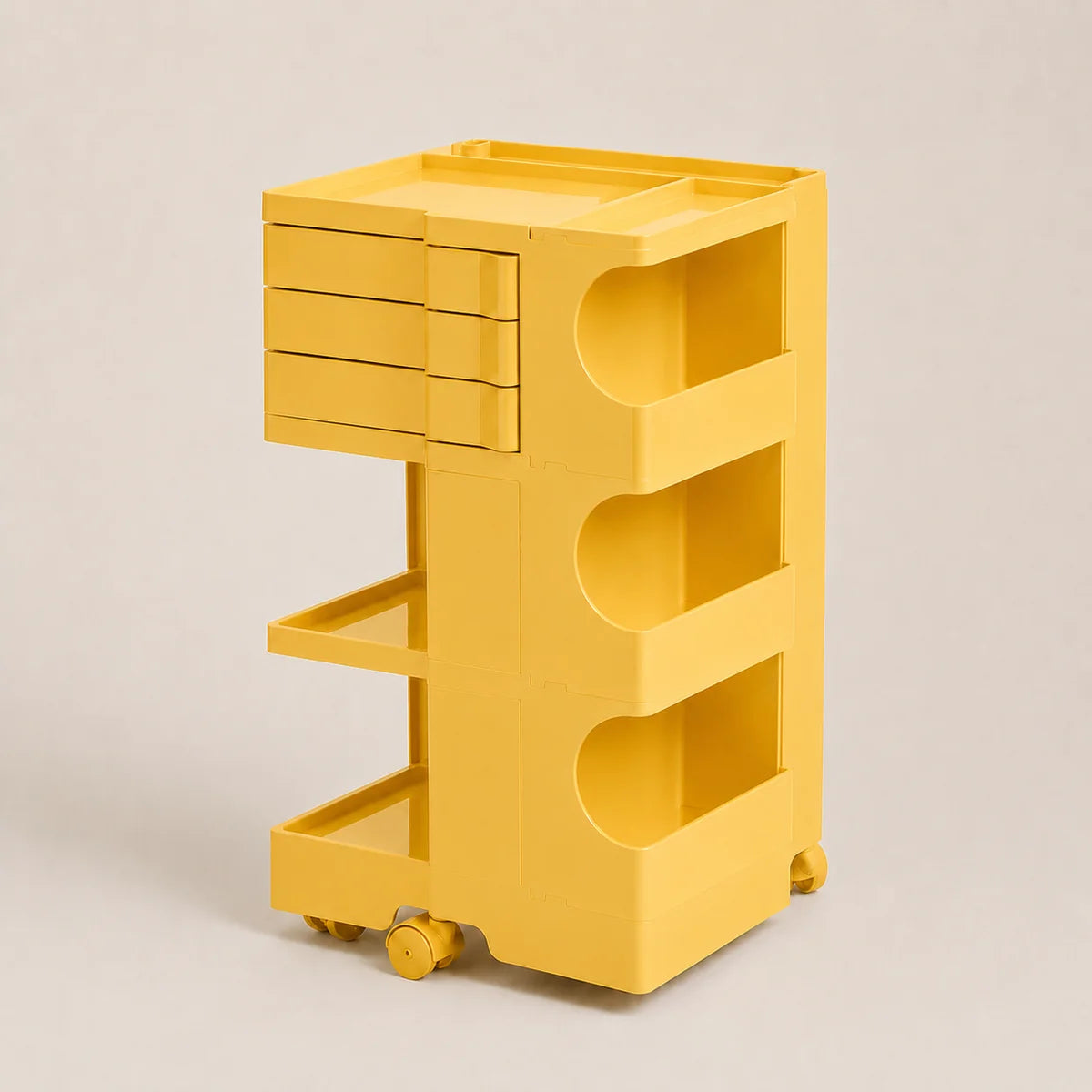 A bright yellow plastic rolling storage cart with three drawers on the top left, three open shelves, and caster wheels, shown on a neutral light beige background.