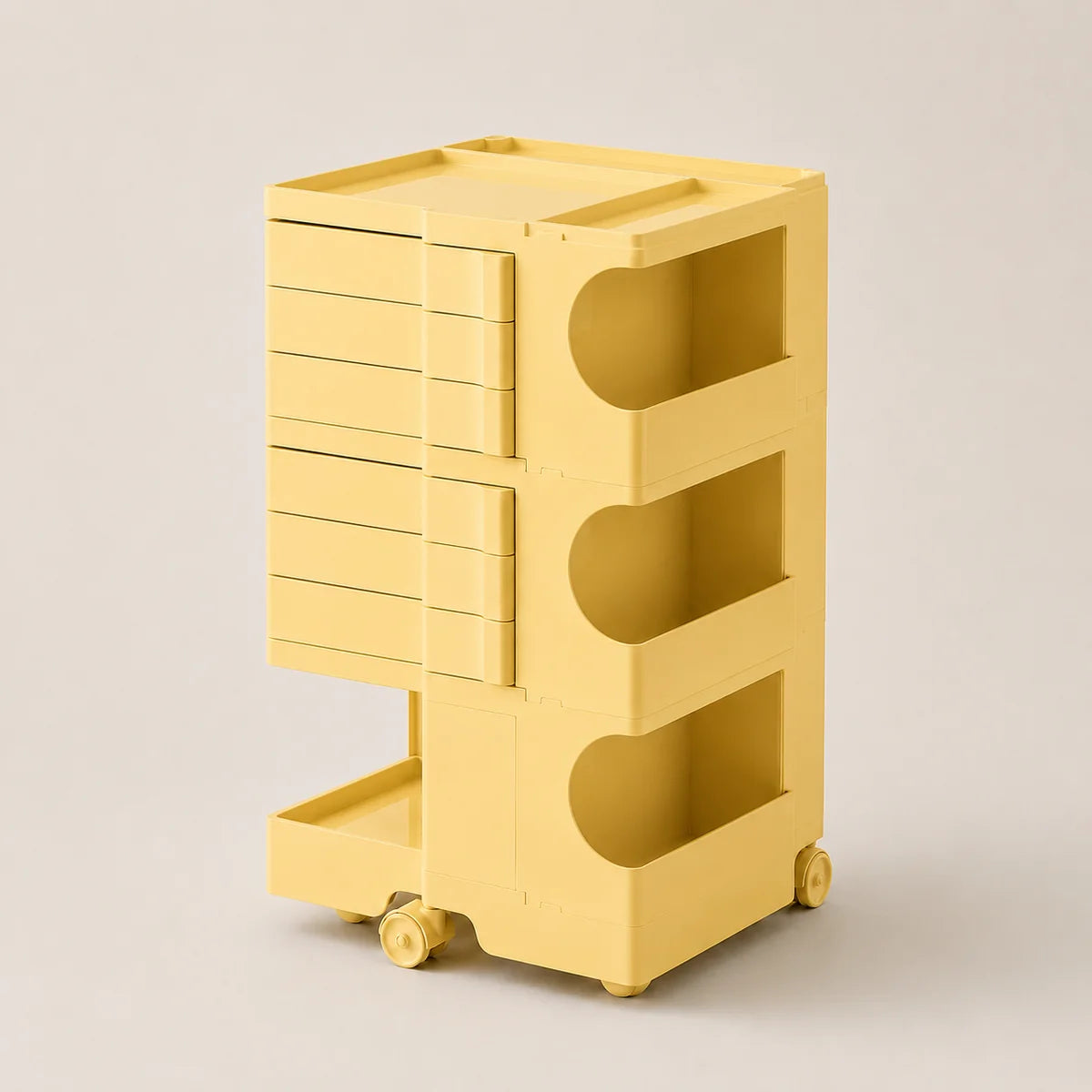 A yellow ABS rolling storage cart with six drawers on the left, three open shelves with curved cutouts on the right, and small caster wheels at the base, shown on a plain light beige studio background.