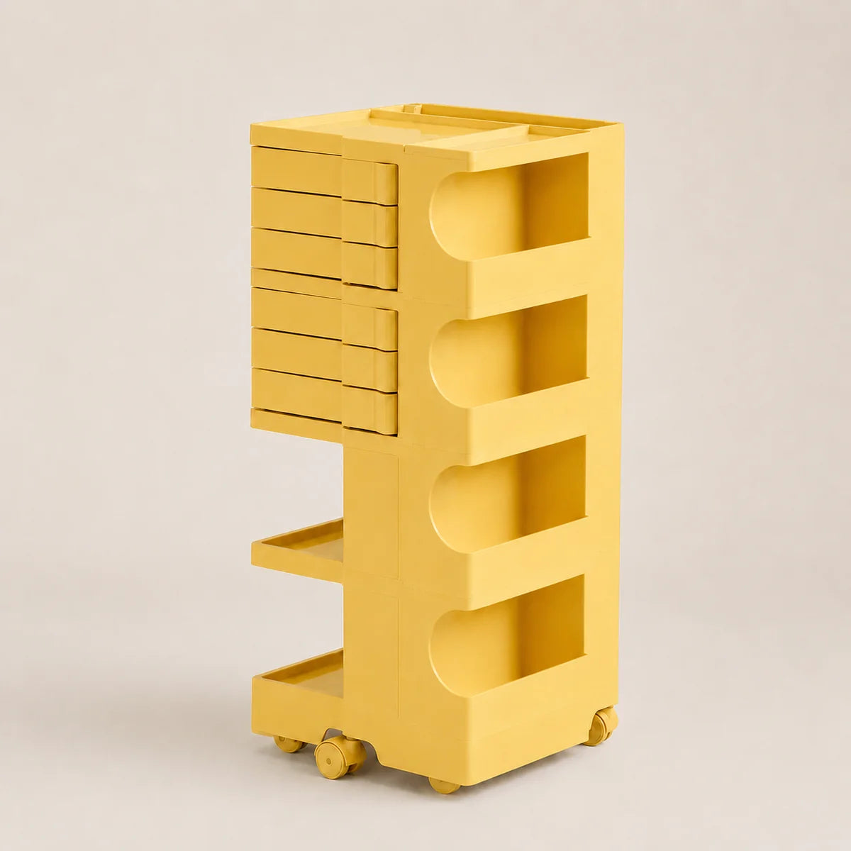 A bright yellow rolling storage organizer with six drawers on the left, four open shelves on the right, and small caster wheels at the base, photographed on a clean light gray studio background.