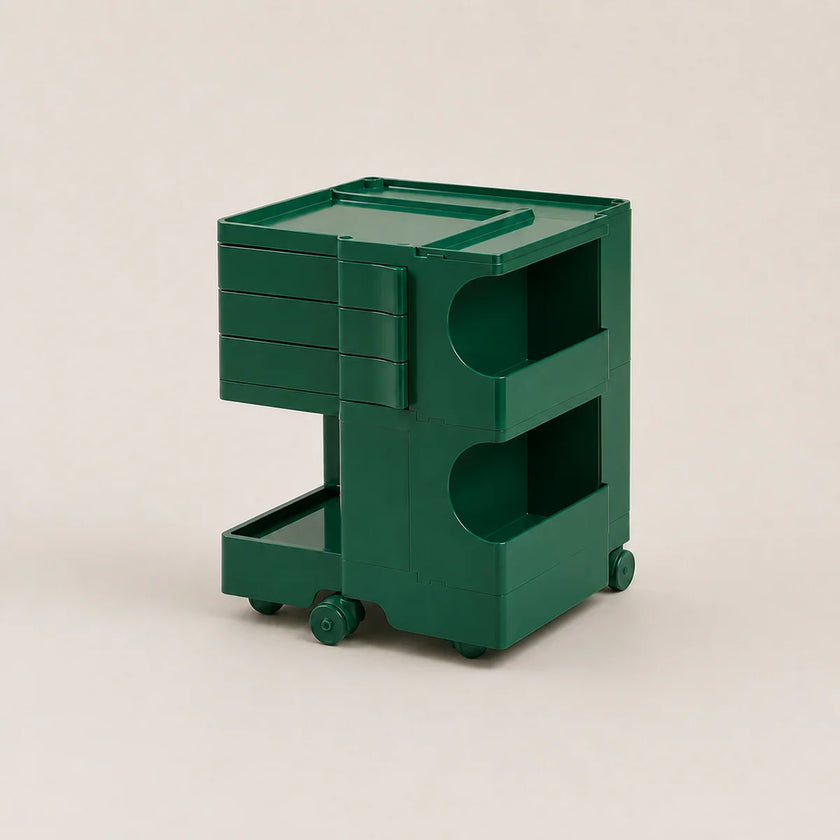 A vintage green plastic rolling storage cart with three drawers on the left, two open shelves on the right, and small caster wheels at the base, photographed on a plain light beige studio background.