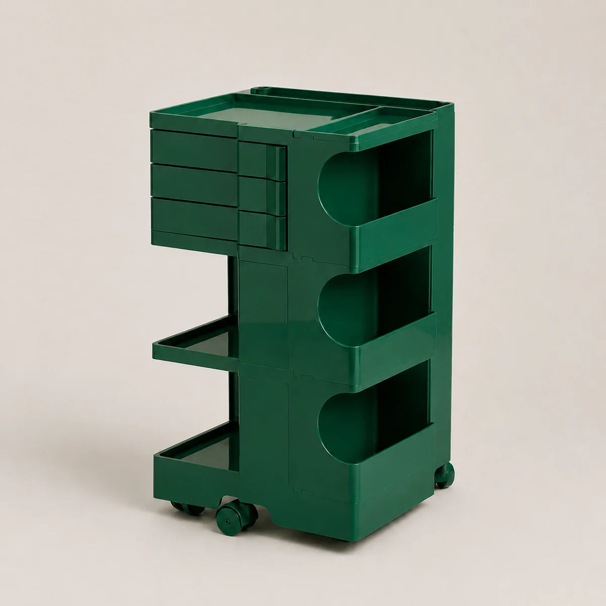 A dark green rolling storage cart with multiple drawers, open shelves, and wheels, photographed on a clean light beige studio background.