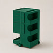 A dark green ABS rolling storage organizer with multiple drawers and open shelves, shown on a plain light beige studio background.