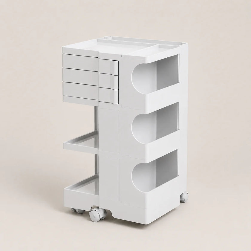 A white rolling storage cart with a top tray, three drawers on the left, three open shelves, and caster wheels, shown on a plain beige studio background.