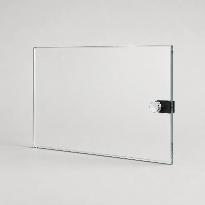 A clear rectangular glass board with a black and silver magnetic clip on the right side, shown on a light gray background.