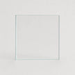 A clear square glass tile or panel standing upright against a light gray background.