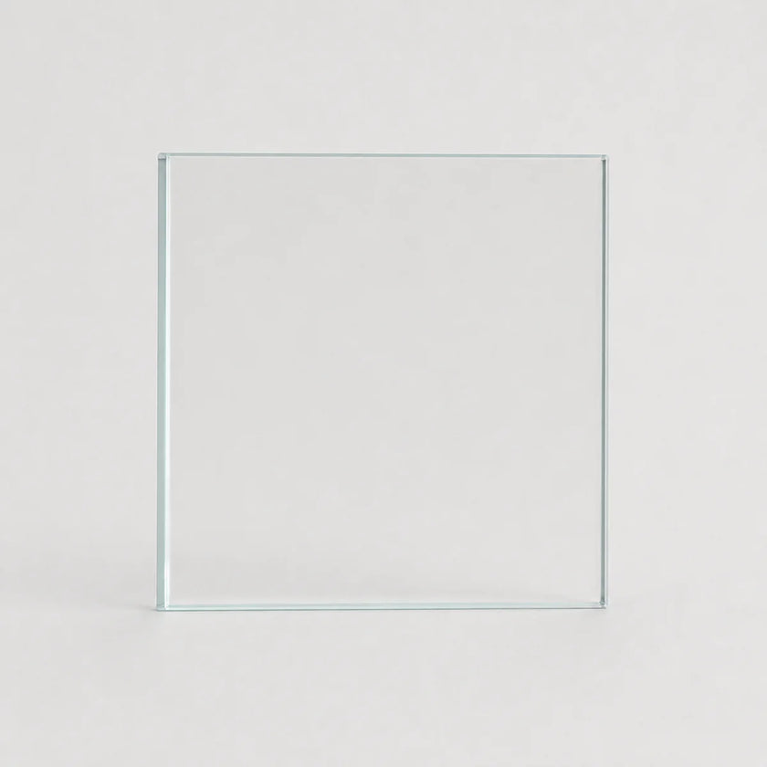 A clear square glass tile or panel standing upright against a light gray background.