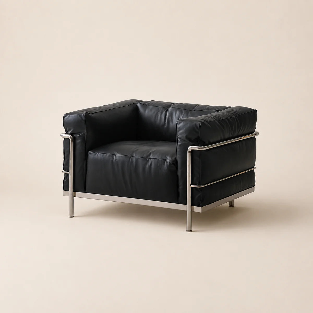 A mid-century modern armchair with black leather upholstery and a polished steel frame, photographed against a solid light beige background.