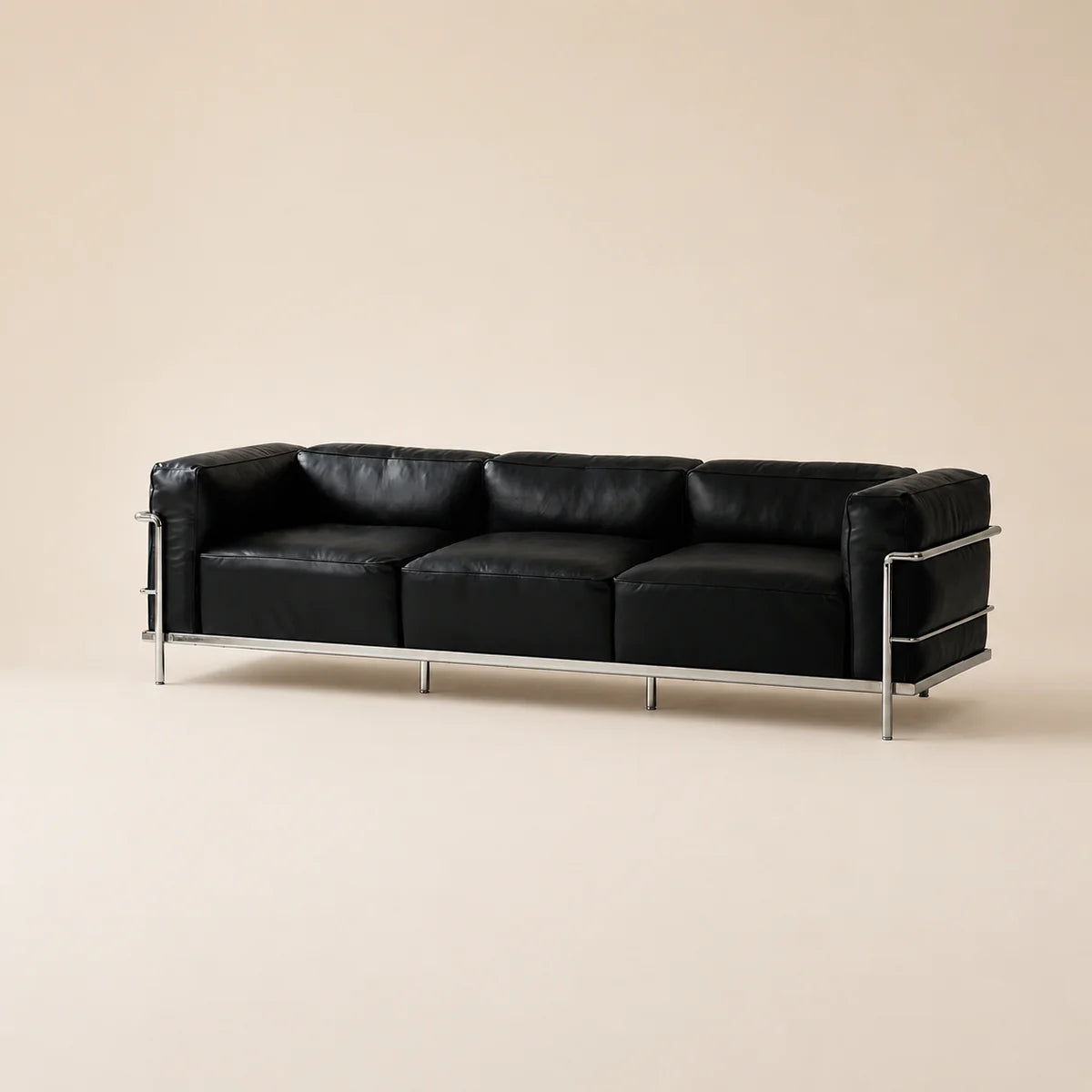 A modern three-seat sofa with black leather cushions and a polished chrome metal frame, set against a solid beige background.