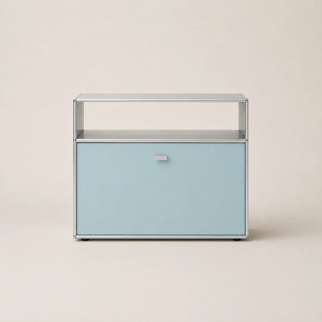 A modern two-tier storage cabinet with a light blue lower drawer and a clear glass upper shelf, set against a solid beige background.
