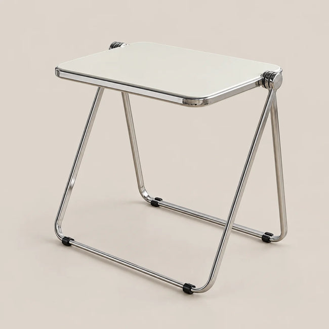 A compact folding side table with a square white top and a chrome metal frame, shown on a solid beige background.