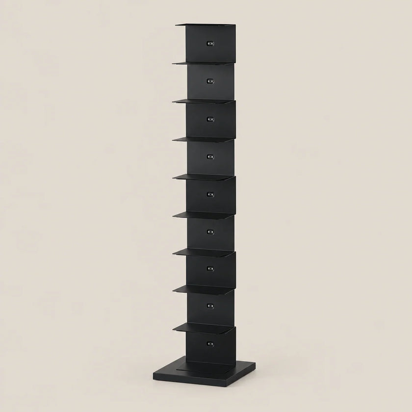 A tall, narrow black metal storage rack with multiple small shelves, shown against a plain warm beige background.