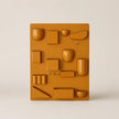 Yellow plastic mold with various shapes on a beige background